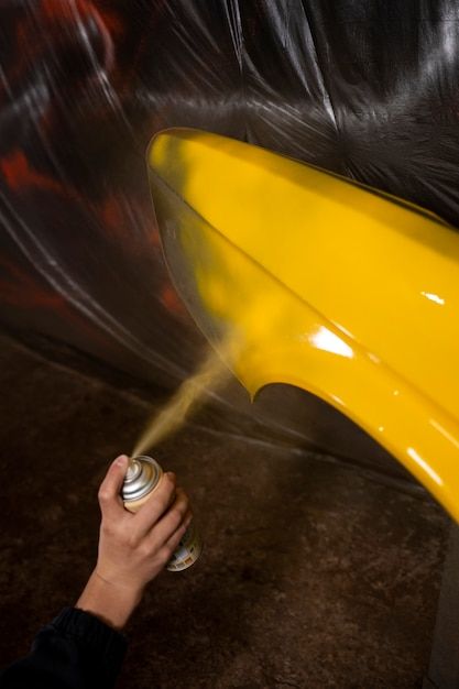 High angle hand spraying powder paint on vehicle