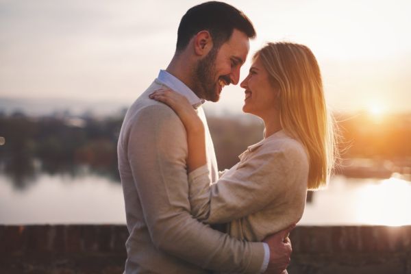 Andrea Mautone and partner sharing a romantic kiss at sunset