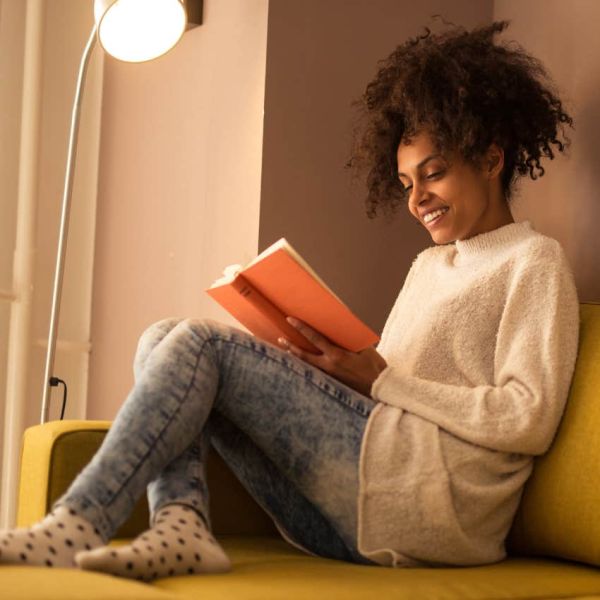 Woman doing self care by reading at home. 