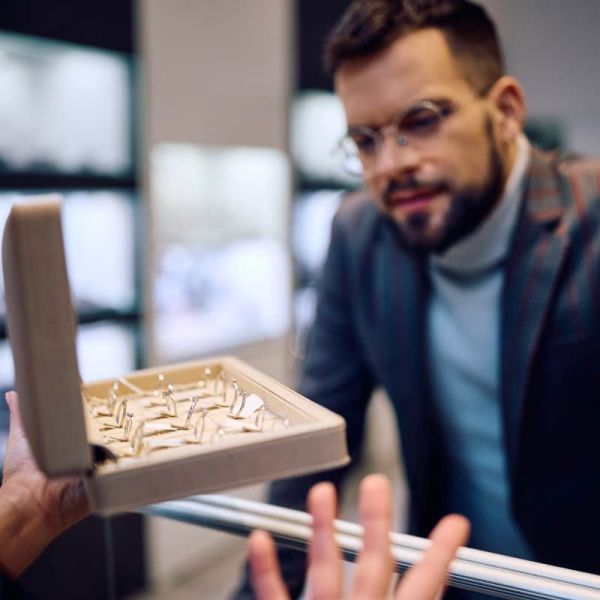 man picking out engagement ring at store