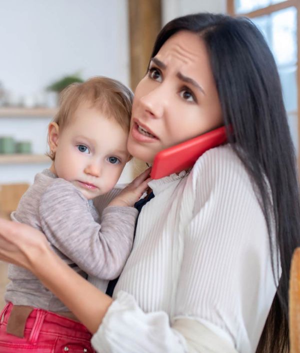 woman holding toddler on the phone