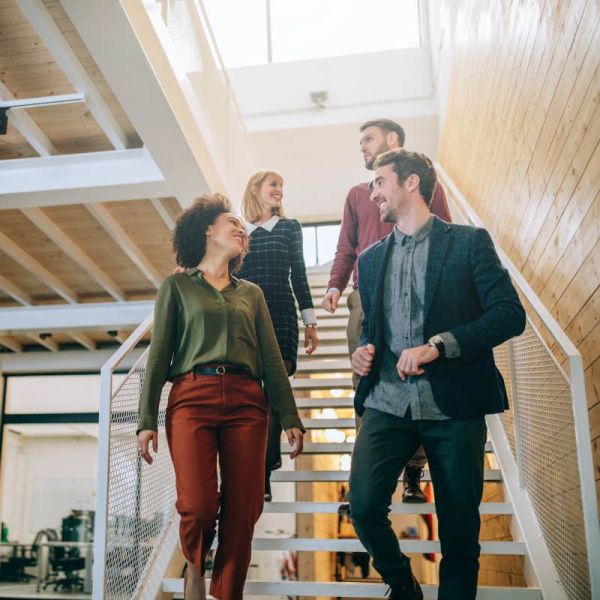 Group of diverse coworkers walking down the stairs in an office