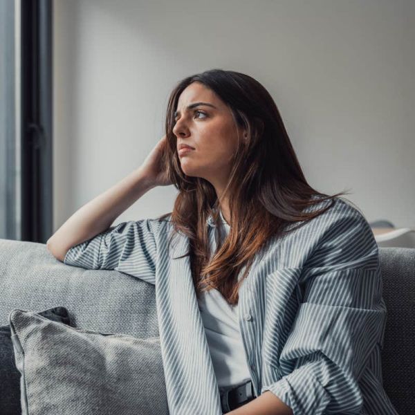 Close up of sad pensive millennial woman sit alone thinking