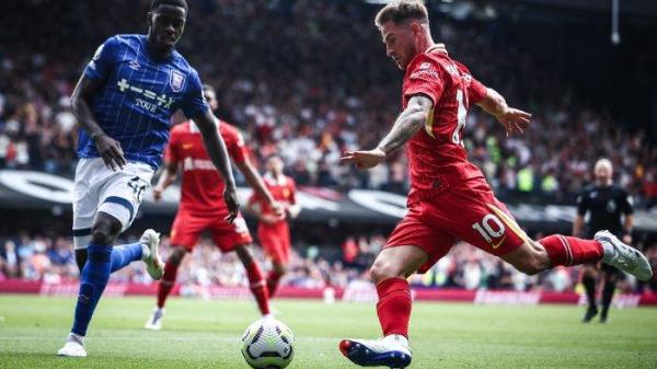 Gelandang Liverpool Alexis Mac Allister (Kanan) menendang bola melewati bek Ipswich Town Axel Tuanzebe selama pertandingan sepak bola Liga Primer Inggris antara Ipswich Town dan Liverpool di Portman Road di Ipswich, Inggris timur pada 17 Agustus 2024.