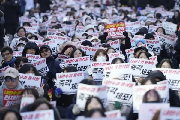 Members of civic groups shout slogans during a news conference demanding the arrest of President Yoon Suk Yeol near the presidential residence in Seoul, South Korea, Tuesday, Dec. 17, 2024. The letters read 