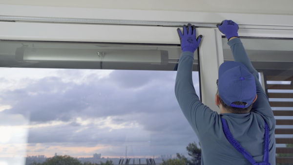 man measuring window frame