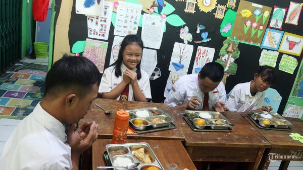 Sebanyak 197 siswa menyantap makan bergizi gratis di Sekolah Luar Biasa (SLB) 5, Slipi, Jakarta, Senin (6/1/2025). Pada hari pertama program makan bergizi gratis (MBG), SPPG Palmerah mendistribusikan 2.987 porsi makanan bergizi ke 11 sekolah di wilayah Slipi, Jakarta Barat dengan menu ayam semur, tumis kacang panjang, tahu goreng tepung, nasi, dan jeruk. Warta Kota/Yulianto