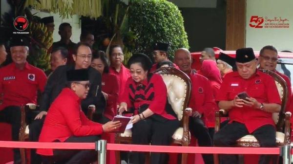 Sekjen  PDIP Hasto Kristiyanto (kiri) tampak berbicara dengan Ketua Umum Megawati Soekarnoputri saat menghadiri perayaan Hari Ulang Tahun atau HUT ke-52 PDIP, di Sekolah Partai Lenteng Agung, Jakarta Selatan, Jumat (10/1/2025). /Youtube PDI Perjuangan