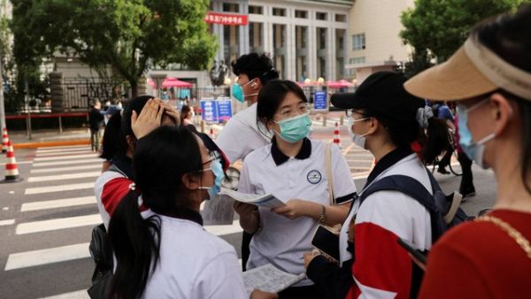 Siswa menunggu untuk memasuki tempat ujian masuk perguruan tinggi nasional tahunan, atau "gaokao", di sebuah sekolah menengah di Beijing, China, Selasa (7/6/2022). Foto: Tingshu Wang/REUTERS