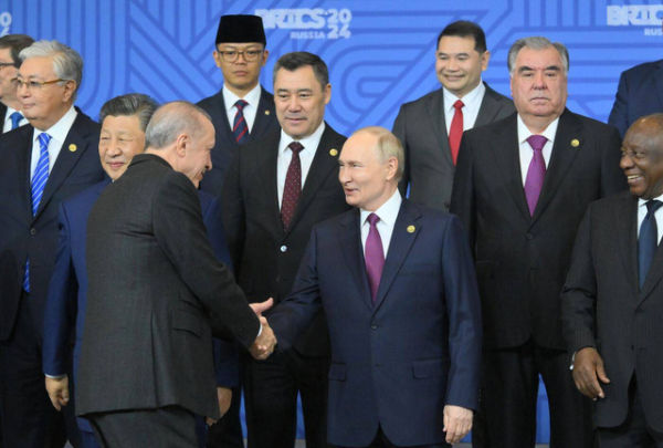 Presiden Rusia V. Putin bersalaman dengan Presiden Turki Erdogan di KTT BRICS di Kazan, 24 Oktober 2024. Tampak Menlu Sugiono berpeci. Foto:  Grigory Sysoev/Photohost agency brics-russia2024.ru