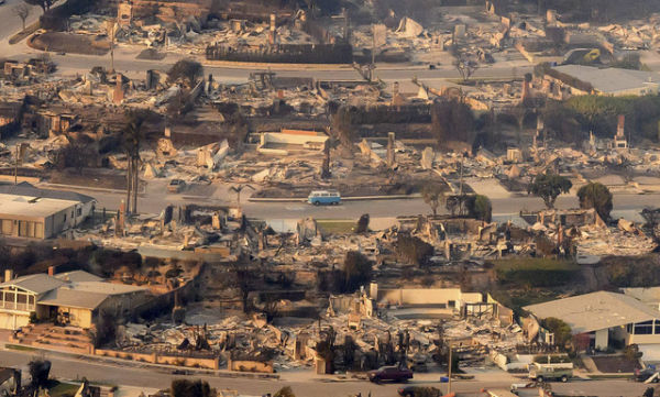 Foto udara kendaraan melewati rumah-rumah yang hancur akibat kebakaran hutan Eaton di California, Amerika Serikat, Jumat (10/1/2025). Foto: Josh Edelson/AFP