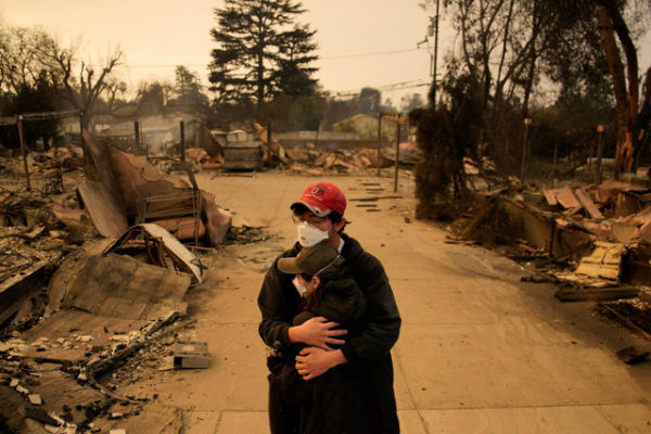 Warga berpelukan di depan rumah mereka yang hancur di Altadena, California, Kamis (9/1/2025). Foto: John Locher/AP Photo