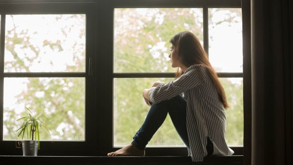 woman thoughtfully looking out window