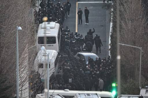 Personel kepolisian dan penyidik lembaga Anti Korupsi Korea Selatan (CIO) berupaya memasuki kediaman Presiden Korsel Yoon Suk-Yeol yang telah dimakzulkan, pada Rabu (15/1), di Seoul. Foto: Anthony Wallace/AFP