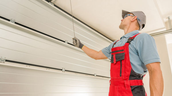 A person pulling on a garage door's manual latch.