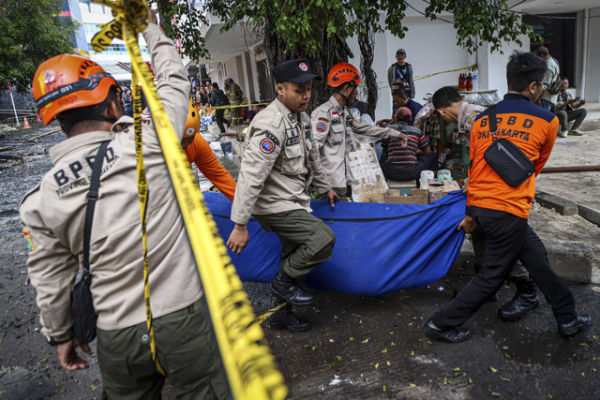 Sejumlah petugas membawa kantung pasca kebakaran di Glodok Plaza, Jakarta, Jumat (17/1/2025). Foto: Iqbal Firdaus/kumparan