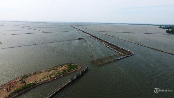 Foto udara lokasi Pagar Laut membentang luas hingga 2 kilometer di di kawasan Pesisir Tarumajaya, Kabupaten Bekasi, Jawa Barat, Rabu (15/1/2025). Nelayan setempat pemasangan pagar laut yang membentang sepanjang 2 km itu mengganggu lalu lintas kapal kecil dan berpotensi merusak ekosistem laut karena adanya pengerukan tanah. Sementara itu Direktorat Jenderal Pengawasan Sumber Daya Kelautan dan Perikanan (PSDKP) Kementerian Kelautan dan Perikanan (KKP) melakukan penyegelan pagar laut di perairan Bekasi dikarenakan tidak memiliki izin Persetujuan Kesesuaian Kegiatan Pemanfaatan Ruang Laut (PKKPRL). WARTA KOTA/ANGGA BHAGYA NUGRAHA