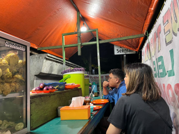 Andi dan Lina di warung pecel lele milik Sugiharjo, di Pejaten Raya, Jakarta Selatan, Sabtu (18/1).  Foto: Alya Zahra/kumparan 