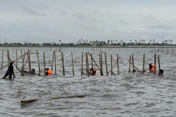 Sejumlah warga dan TNI AL berusaha membongkar pagar laut di perairan Tangerang, Banten, Sabtu (18/1/2025). Foto: Abid Raihan/kumparan