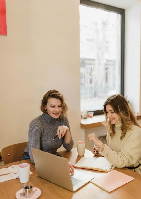 women talking while looking at computer