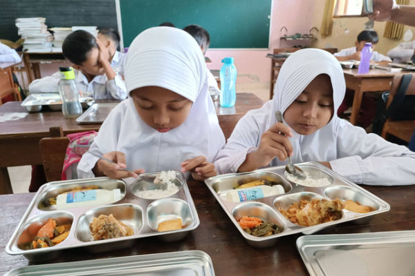 Murid menikmati paket makan program Makan Bergizi Gratis (MBG) di SD Sinduadi Timur, Kapanewon Mlati, Kabupaten Sleman, Senin (13/1/2025). Foto: Arfiansyah Panji Purnandaru/kumparan