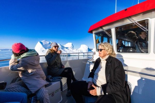 Pengunjung di kapal wisata melewati gunung es yang mengapung di Disko Bay, Ilulissat, Greenland barat, 1 Juli 2022. Foto: Odd Andersen/AFP