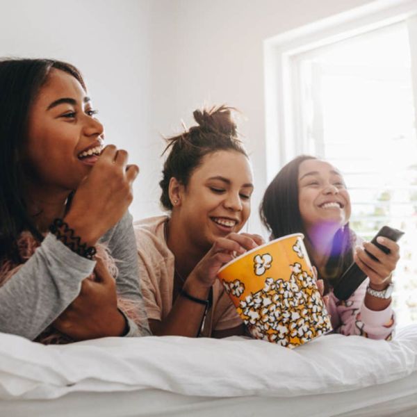 teenage girls in bed eating popcorn