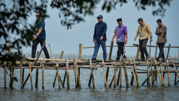 Menteri Agraria dan Tata Ruang/Kepala Badan Pertanahan Nasional (ATR/BPN) Nusron Wahid (kedua kiri) berjalan melewati jembatan saat meninjau pagar laut di Pantai Anom, Desa Kohod, Kabupaten Tangerang, Banten, Jumat (24/1/2025). Foto: ANTARA FOTO/Putra M. Akbar