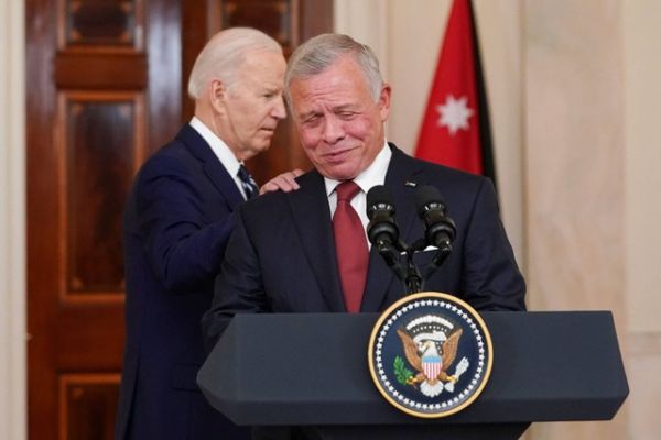 Eks Presiden AS Joe Biden menyentuh bahu Raja Abdullah dari Yordania, saat mereka menghadiri konferensi pers, setelah pertemuan mereka, di Gedung Putih di Washington, AS, 12 Februari 2024.  Foto: REUTERS/Kevin Lamarque