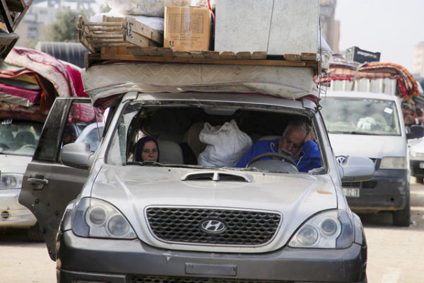 Warga Palestina duduk di dalam kendaraan saat mereka menunggu untuk diizinkan kembali ke rumah mereka di Gaza tengah, Minggu (26/1/2025). Foto: Hatem Khaled/REUTERS