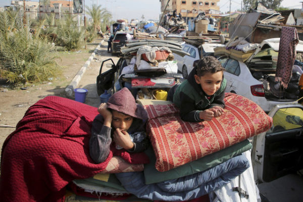 Anak-anak Palestina menunggu untuk diizinkan kembali ke rumah mereka di Gaza tengah, Minggu (26/1/2025). Foto: Hatem Khaled/REUTERS