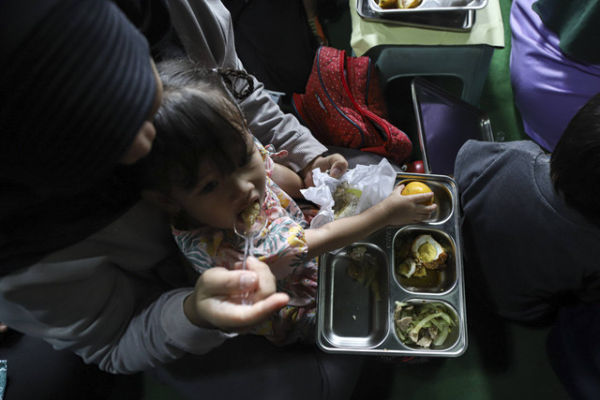 Seorang ibu menyuapi anaknya saat pelaksaan Makan Bergizi Gratis (MBG) di kawasan Ciracas, Jakarta, Jumat (10/1/2025). Foto: Iqbal Firdaus/kumparan