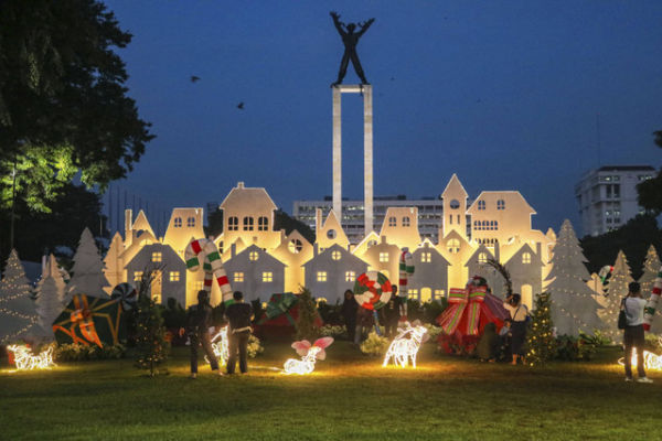 Sejumlah warga bermain dengan latar belakang dekorasi khas Natal di Taman Lapangan Banteng, Jakarta, Senin (23/12/2024). Foto: Idlan Dziqri Mahmudi/ANTARA FOTO