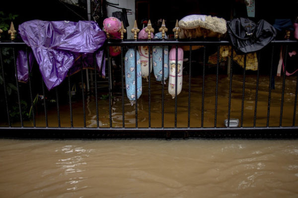 Perlengkapan tidur warga Cipinang disangku di pagar saat dilanda banjir pada 19 Februari 2021. Foto: Jamal Ramadhan/kumparan