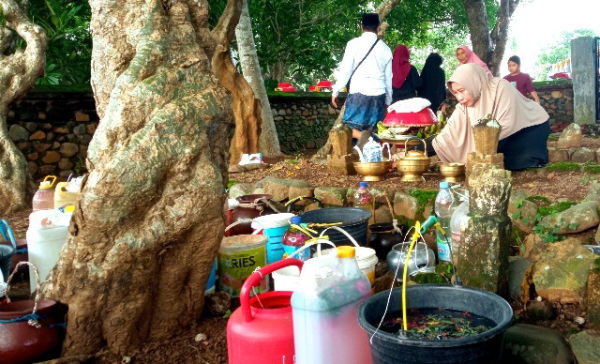 Air suci diletakkan mengitari makam leluhur. foto: L Dedy S