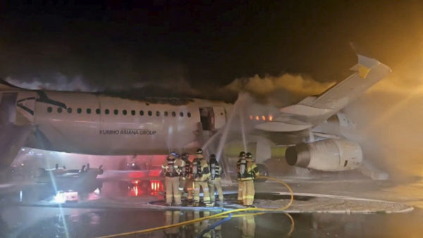 Petugas pemadam kebakaran berusaha memadamkan api dari pesawat Air Busan di Bandara Internasional Gimhae di Busan, Korea Selatan, Selasa (28/1/2025). Foto: YONHAP NEWS AGENCY via REUTERS