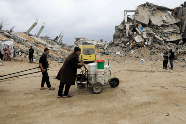 Warga Palestina mendorong kereta dorong berisi tangki air di kamp pengungsi Jabalia, jalur Gaza utara, Rabu (5/2/2025). Foto: Mahmoud Issa/REUTERS