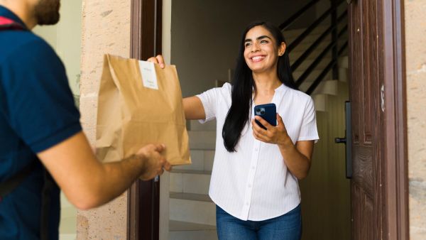 Woman experiencing lifestyle creep getting food delivered