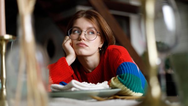 Unhappy woman who automatically said yes to an expensive outing and is experiencing lifestyle creep