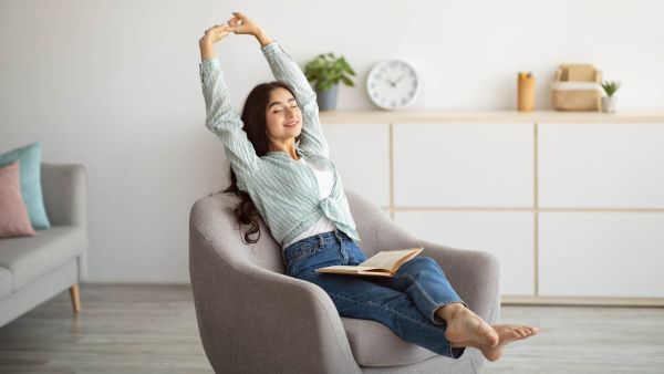 Millennial woman relaxing and reading a book at home