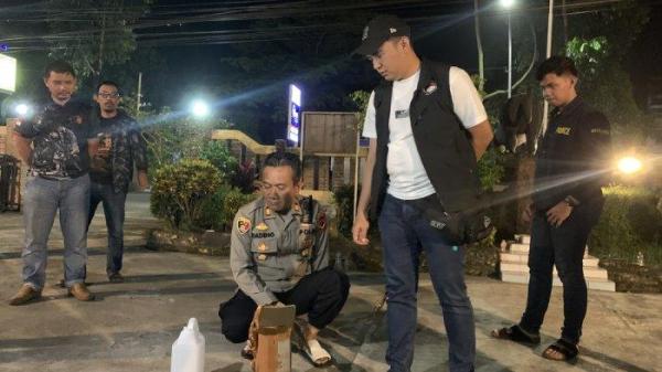 ALKOHOL MURNI - Kasat Narkoba Polres Cianjur AKP Septian Pratama saat memperlihatkan alkohol murni yang dikonsumsi warga Cianjur di Mapolsek Mande, Sabtu (8/2/2025) dini hari.