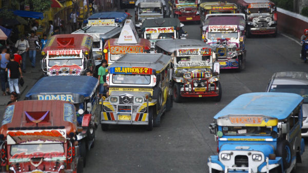 Several colorful jeepneys on a road in Manila, Philippines