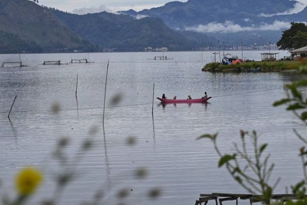 Warga mendayung perahu kayunya saat memancing di Danau Laut Tawar, Takengon, Aceh, Senin (19/9/2022). Foto: Chaideer Mahyuddin/AFP