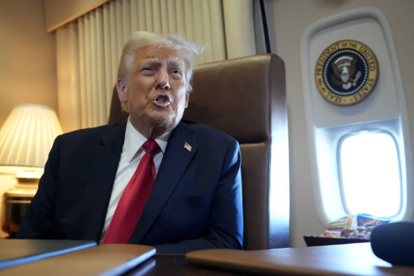 Donald Trump di dalam pesawat kepresidenan pada Senin (10/2/2025). Foto: Ben Curtis/Pool via Reuters