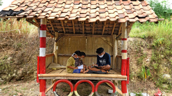 Sejumlah murid SD Negeri Jakung mengikuti proses belajar mengajar secara daring di pos ronda di tepi jalan supaya bisa mendapat sinyal di Kampung Gunungsari, Serang, Banten, Rabu (29/7). Foto: Asep Fathulrahman/ANTARA FOTO