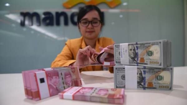 Seorang Teller menghitung uang Rupiah dan Dolar Amerika Serikat di Bank Mandiri, Jakarta, Senin (7/1/2018). Rupiah ditutup menguat 1,26 persen menjadi Rp14.085 per satu Dolar AS. Foto: ANTARA FOTO/Akbar Nugroho Gumay