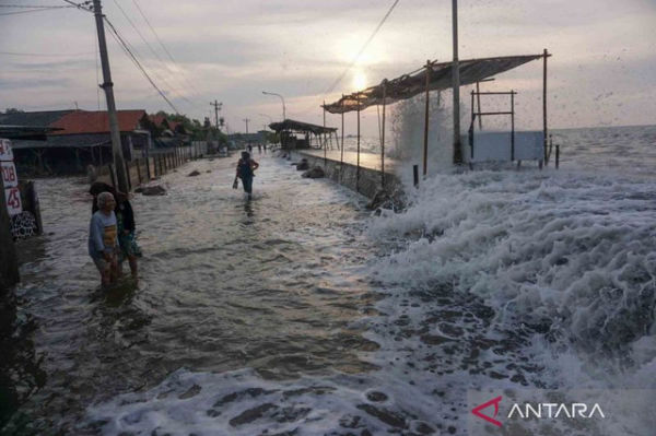 Sejumlah warga berjalan menghindari gelombang air laut di pesisir pantai Utara, Pekalongan, Jawa Tengah, Senin (23/5/2022). Foto: ANTARA FOTO/Harviyan Perdana Putra