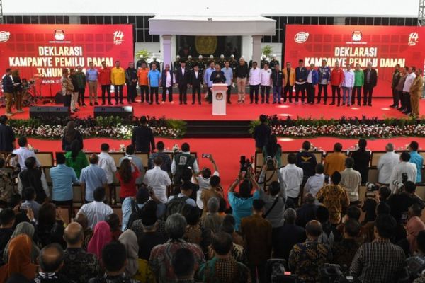 Ketua KPU Hasyim Asy'ari (tengah) beserta ketiga pasangan calon presiden dan calon wakil presiden serta perwakilan pimpinan 18 partai politik membacakan Deklarasi Kampanye Pemilu Damai 2024 di kompleks Kantor KPU, Jakarta, Senin (27/11/2023). Foto: Aditya Pradana Putra/ANTARA FOTO