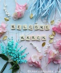 This may contain: the word welcome march spelled with scrabbles and flowers