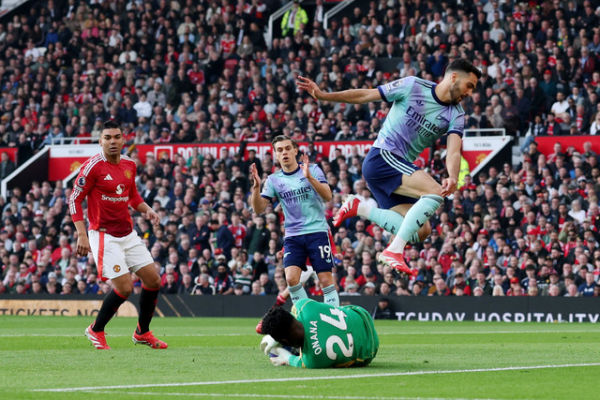 Penjaga gawang Manchester United Andre Onana berebut bola dengan pemain Arsenal Mikel Merino pada pertandingan Liga Inggris di Old Trafford, Manchester, Inggris, Minggu (9/3/2026). Foto: Phil Noble/REUTERS